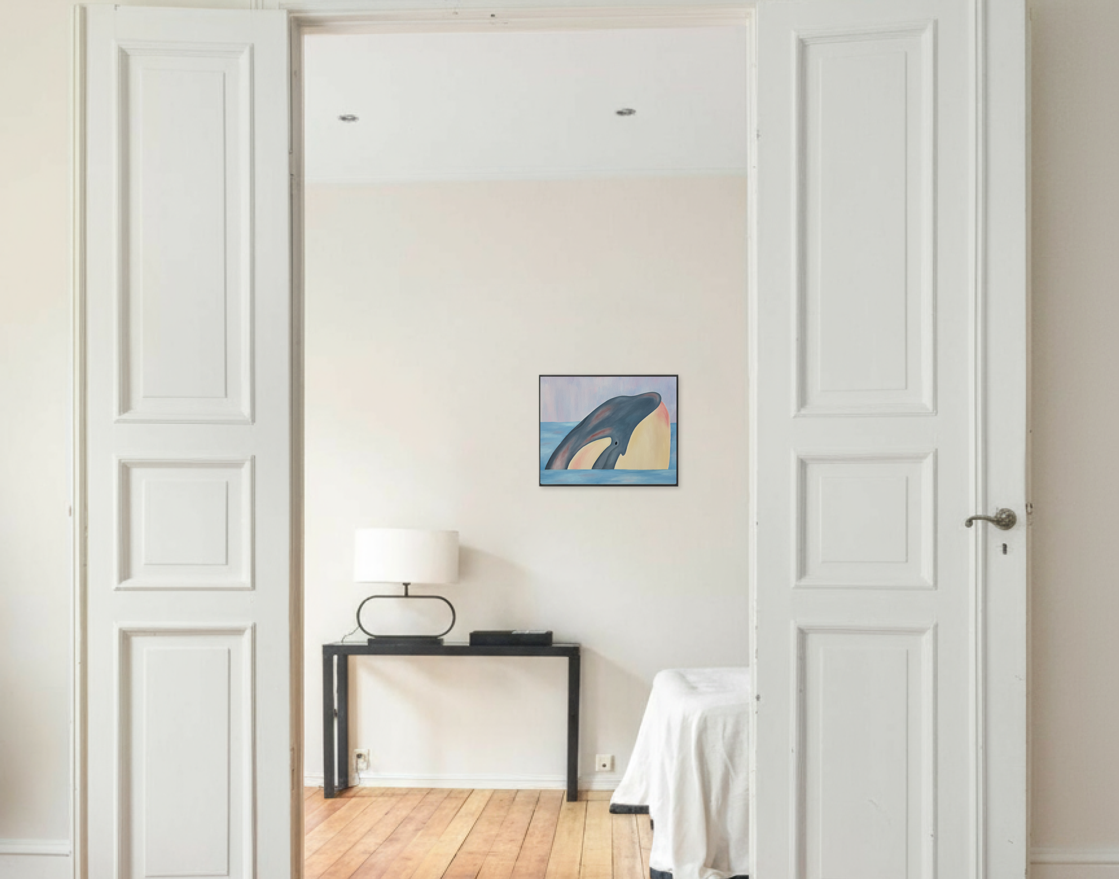Картина маслом на холсте с изображением головы кита, выныривающего из воды, висит на светлой стене в интерьере комнаты с белыми дверями, черным консольным столом, белой лампой и частью кровати